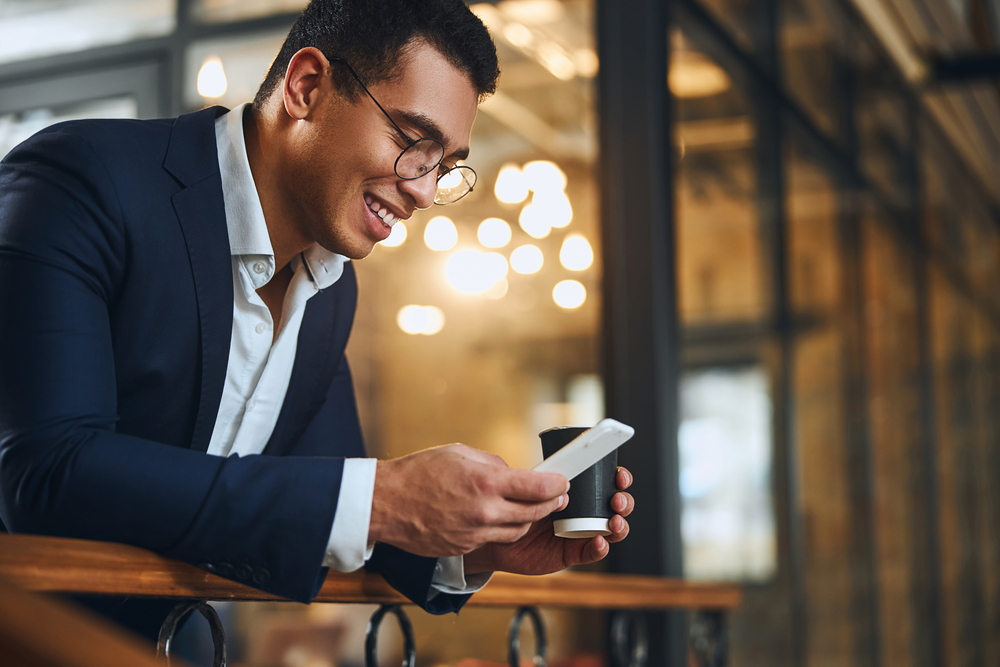 Man using a phone to check revenue streams